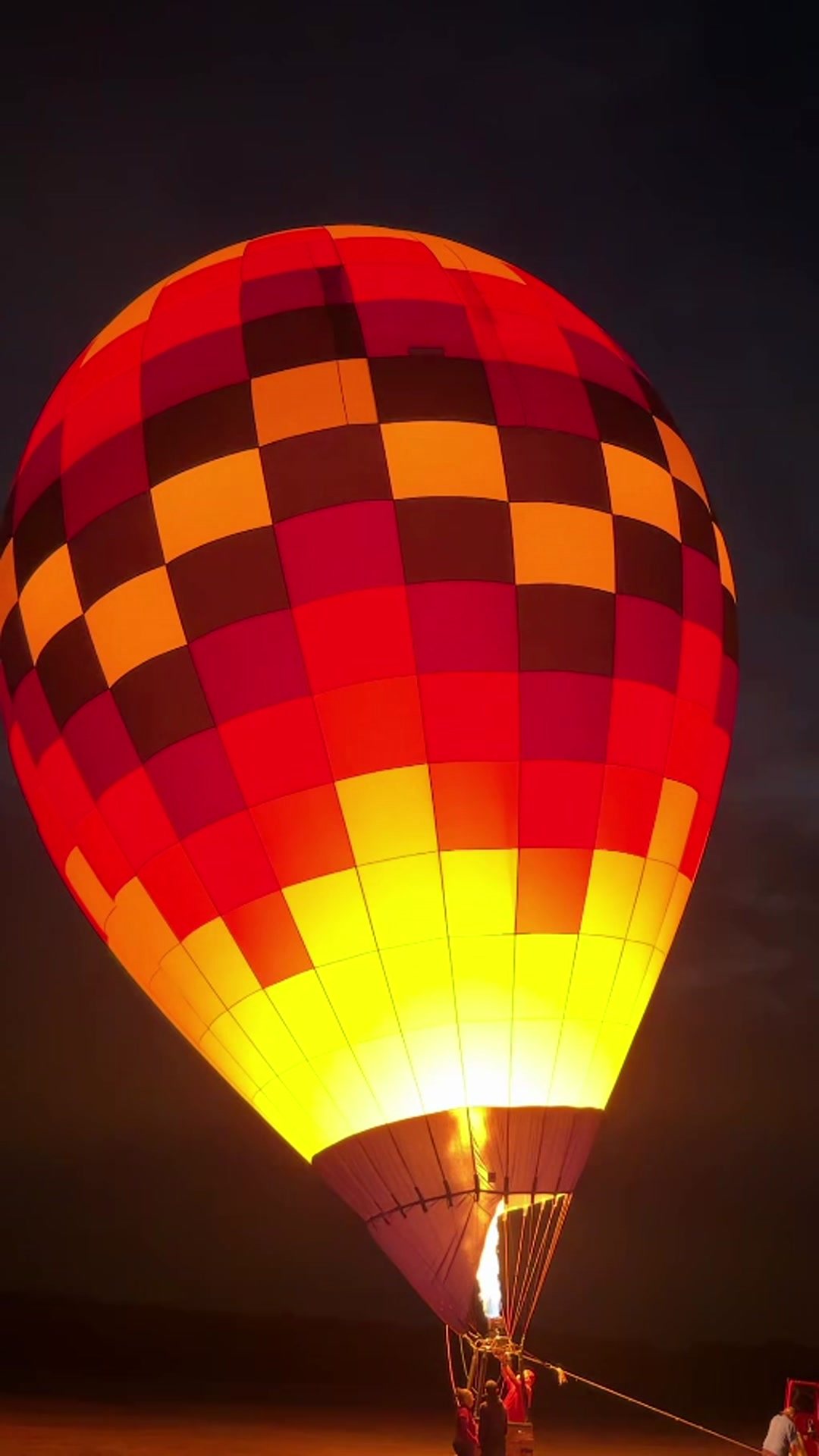 Hot air balloon glowing against the night sky