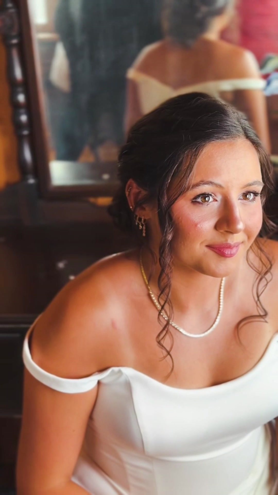 Bride getting ready, seated at a mirror